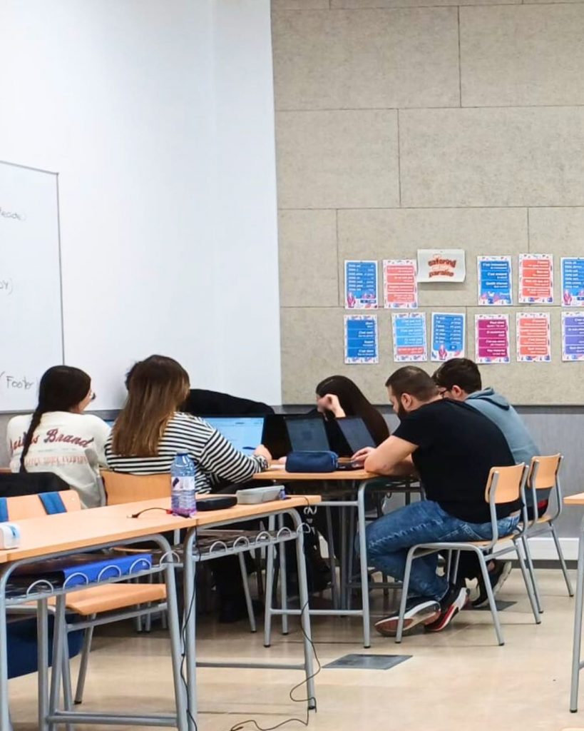 Grupo de estudiantes del ciclo de Asistencia a la Dirección trabajando en equipo en el aula, usando sus portátiles para organizar la Andada y Chocolatada  2025